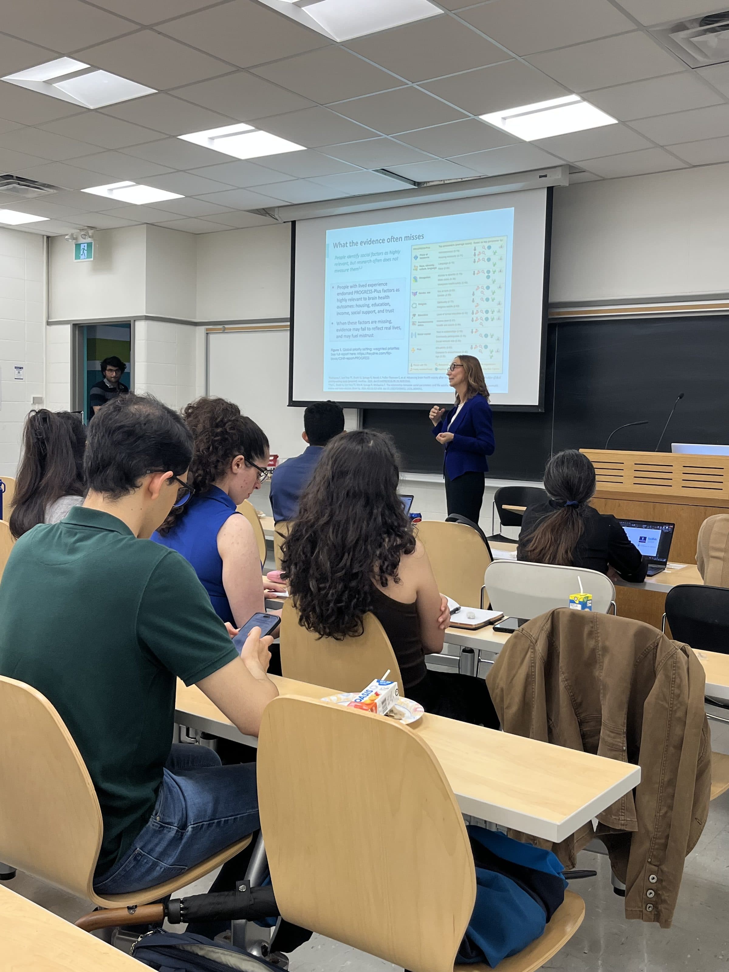 A researcher presenting to students at a MIND UofT event